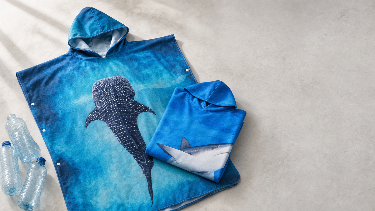 New brands added to Lotz Outdoors this week: Kahu Tribe microfiber towel ponchos with painterly ocean-life illustrations, made from recycled plastic bottles, shown alongside recycled PET bottles on a neutral studio surface.