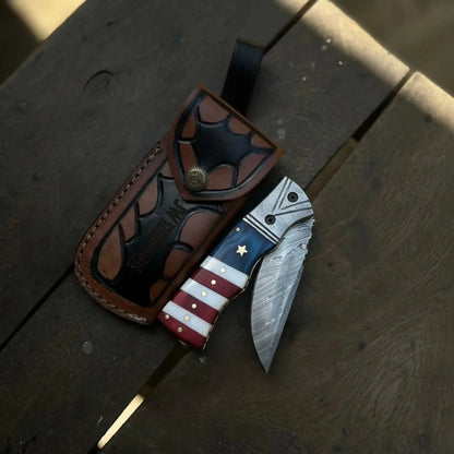 Damascus Folding Pocket Knife — American Flag Handle, Damascus Bolster, Linear Lock &amp; Hand Engraved Leather Sheath